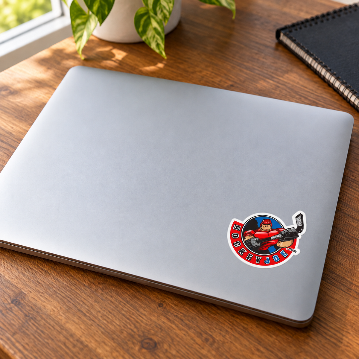 Hockey Joe logo sticker on a silver laptop — lifestyle mockup.