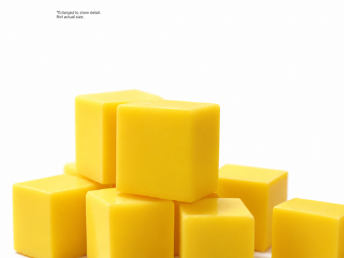 Yellow hockey wax pieces on a white background. Enlarged to show detail, not actual size.